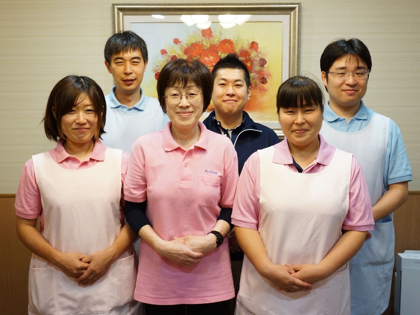 前方に女性スタッフ、後方に男性スタッフがそれぞれ３人ずつ並んでいる。そのうちの４人はエプロンをつけている。