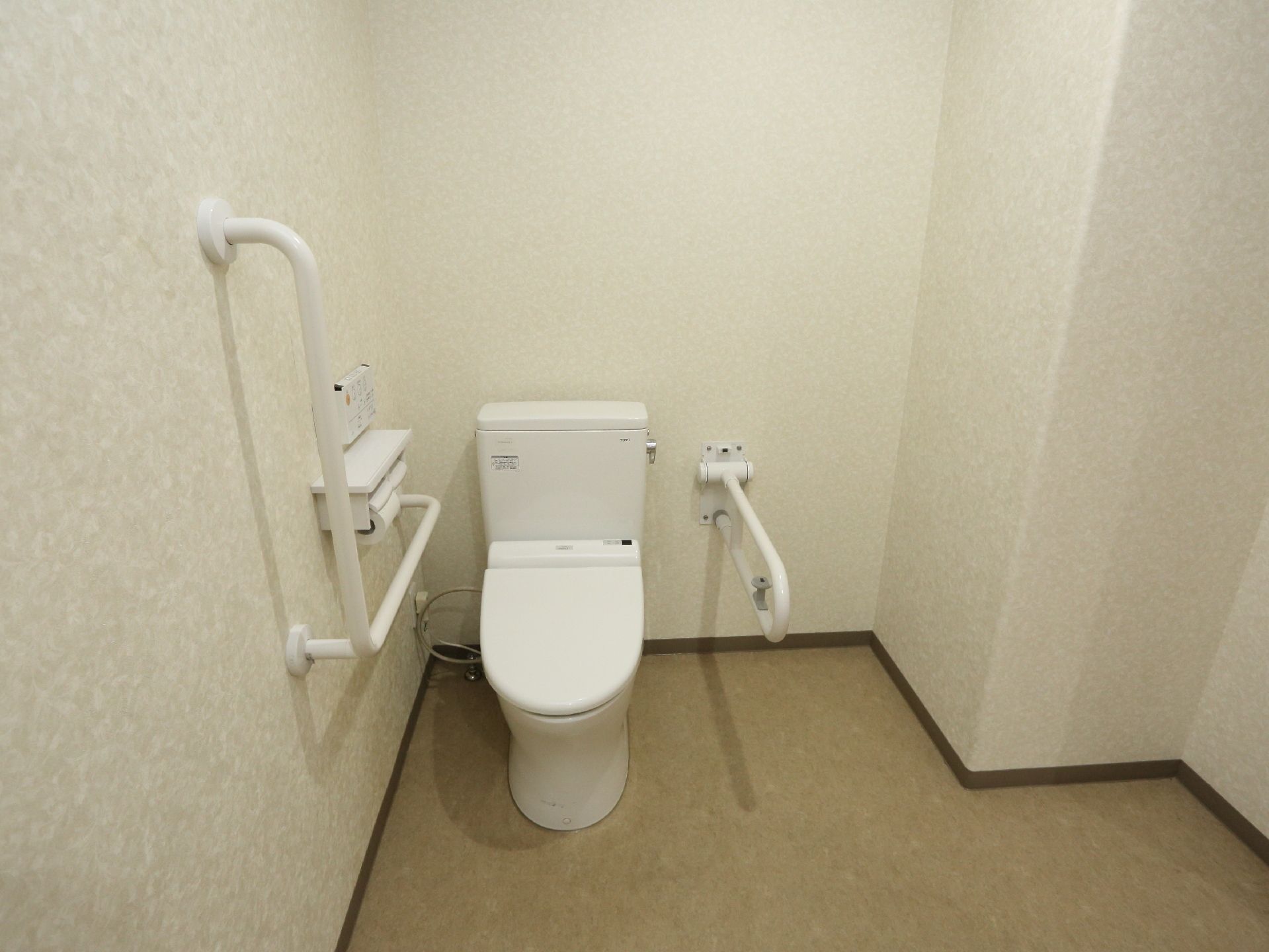 広々としたトイレなので車いすを利用している方も動きやすくなっている。洋式便器の両側には手すりが付いている。