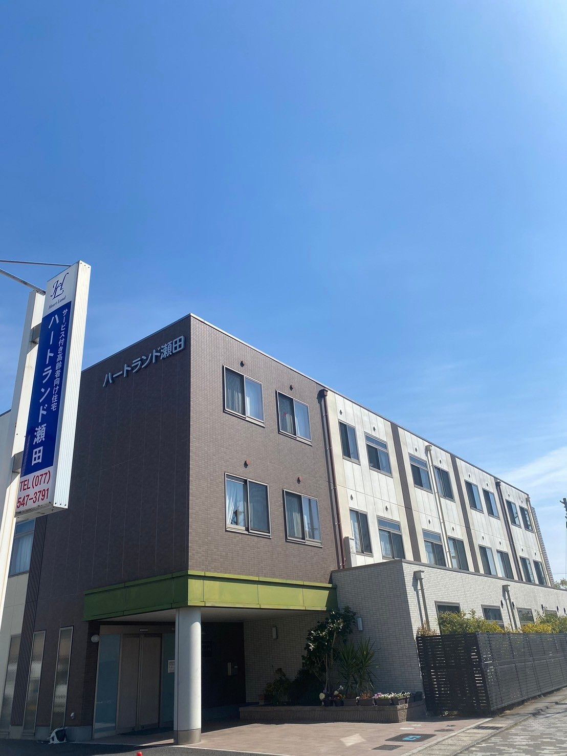 介護車両へ移動する車椅子に乗った高齢女性と介助をする女性ヘルパー