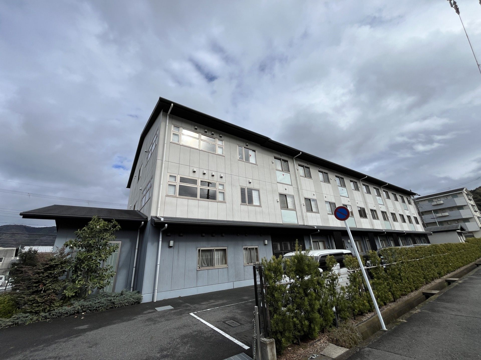 介護車両へ移動する車椅子に乗った高齢女性と介助をする女性ヘルパー