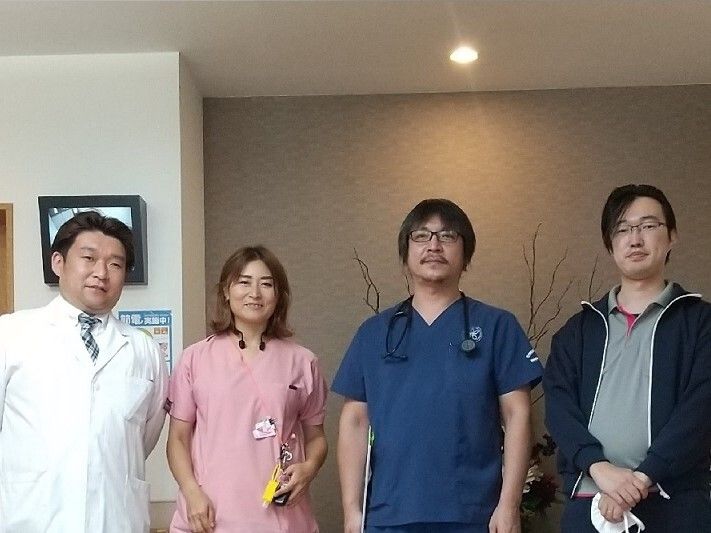 車椅子に座っている高齢男性と隣りに寄り添う女性ヘルパー