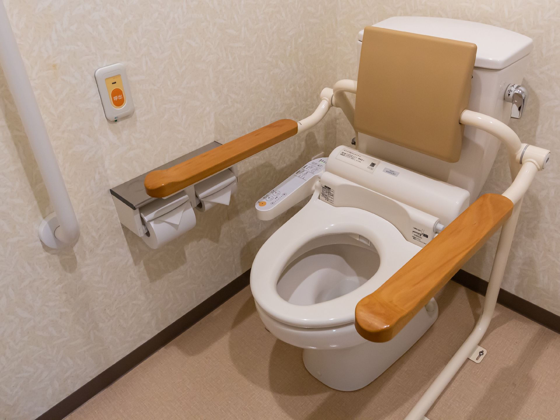 バリアフリー完備で、壁に手すりが付き、床の段差が解消されているトイレ
