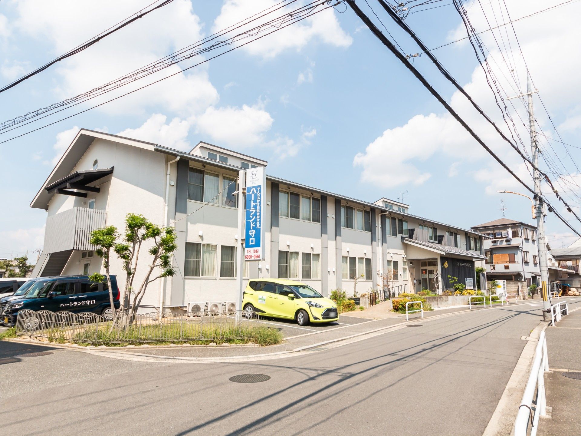笑顔の介護士に囲まれた車椅子に座っている高齢女性