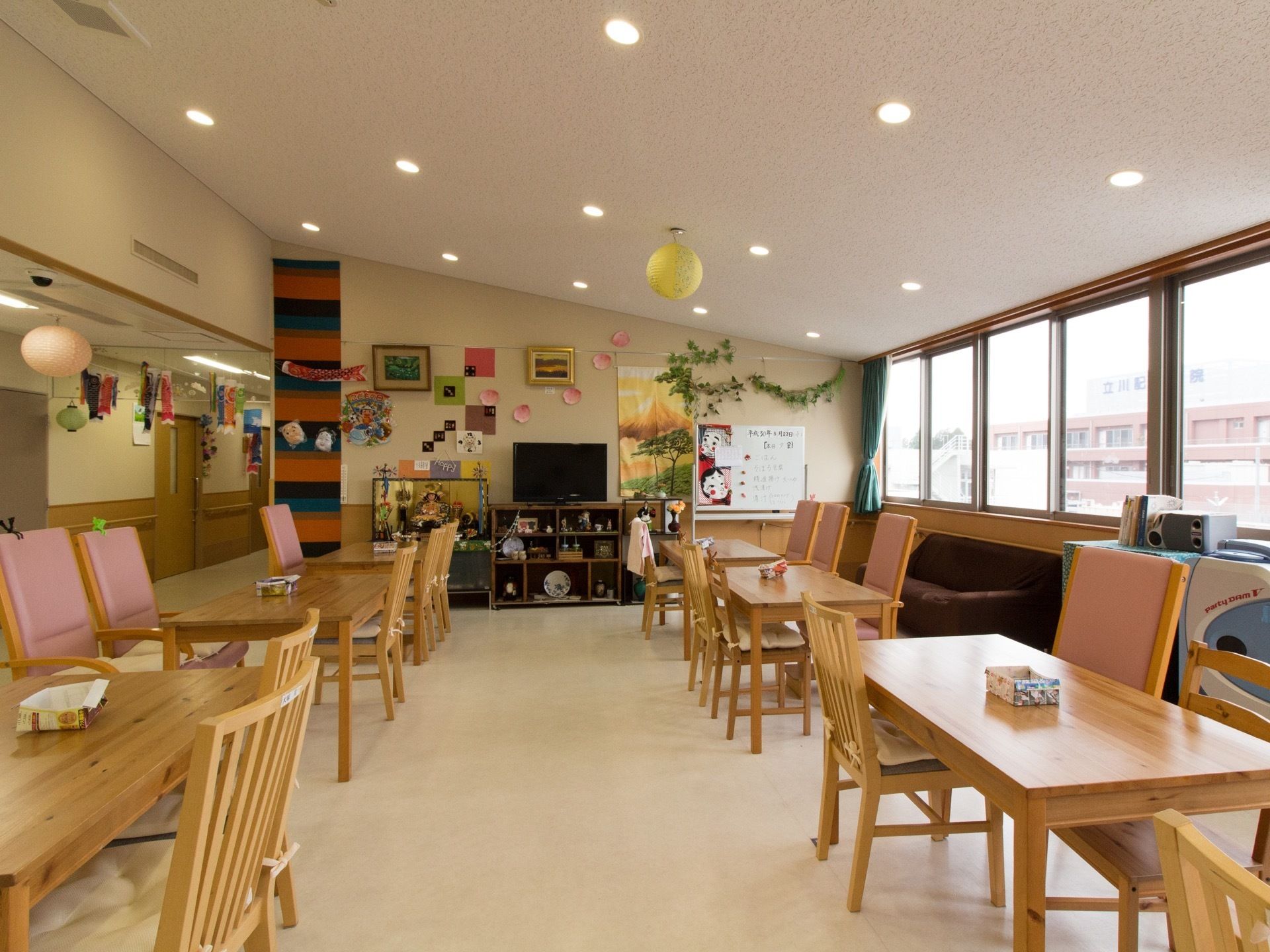 奥の壁はタペストリーなどで飾り付けられており、賑やかな雰囲気になっている。テレビの置かれた棚にも、皿や小物が置かれている。