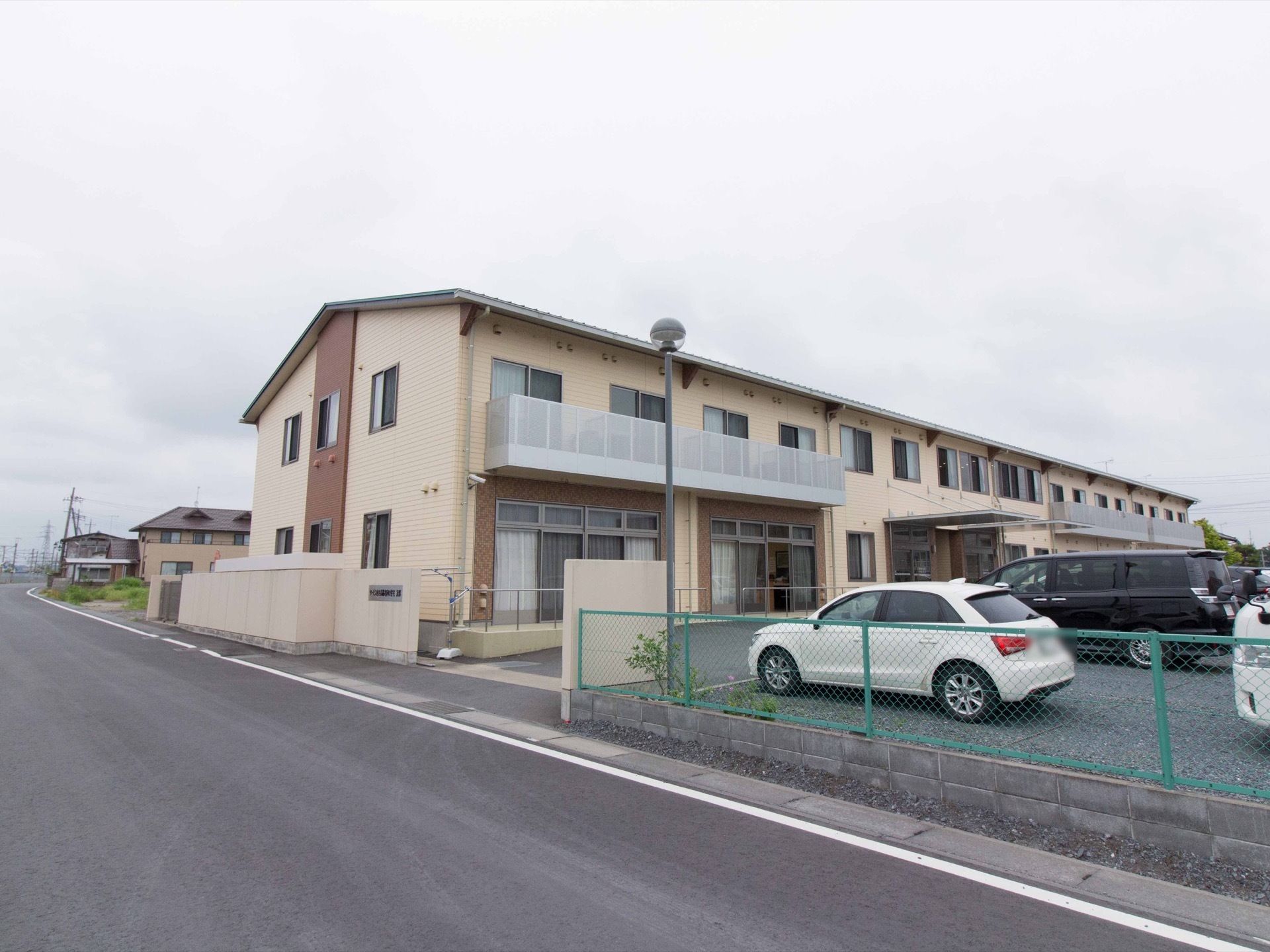 薄いレンガ色に濃いブラウンのアクセントが印象的な２階建ての建物。耐震性に優れた鉄骨造りになっている。