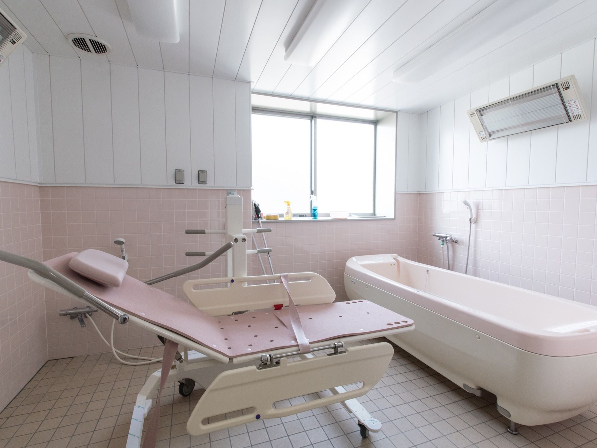 ピンク色を基調とした浴室には、体の不自由な入居者様専用の入浴介助器具が設置されており、介助の上入浴が可能である。