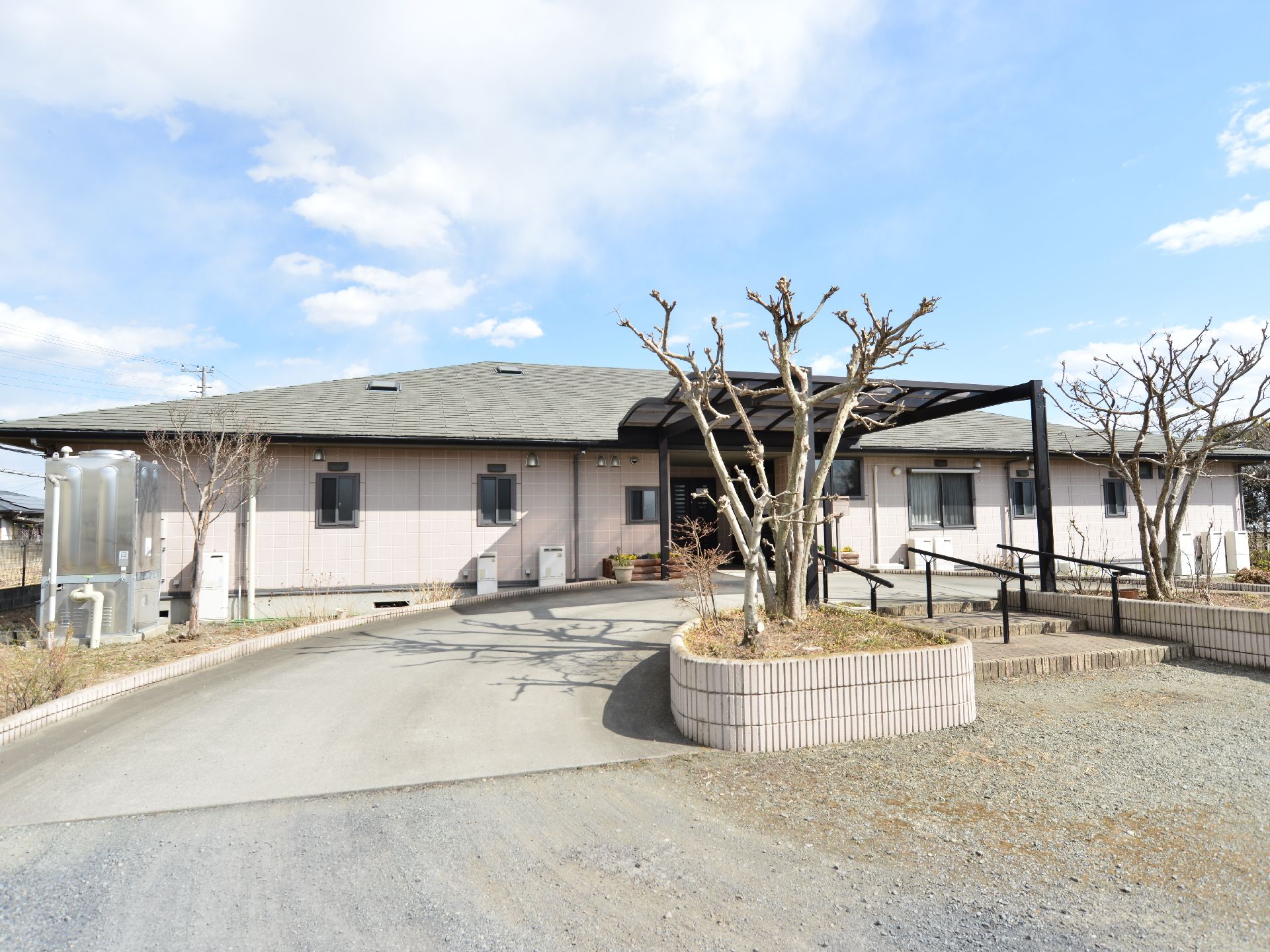 平屋建ての建物の周りには背の高い建造物は見当たらず、広々した環境である。スロープが左右両側から、建物に向かって伸びている。