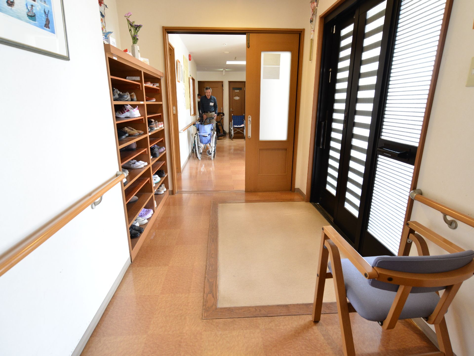 出入り口から館内へとバリアフリーでつながっている。履物入れが正面に据え付けられ、使いやすい。靴の脱着がしやすいよう、椅子が設置されている。