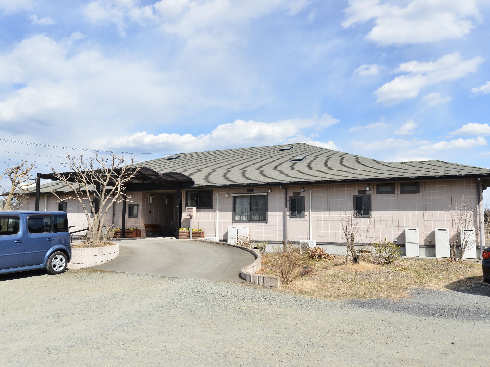 平屋建ての建造物が、ゆとりある敷地に建つ。入り口に向かってなだらかなスロープになっている。大きなひさしがあり、雨の日も楽。