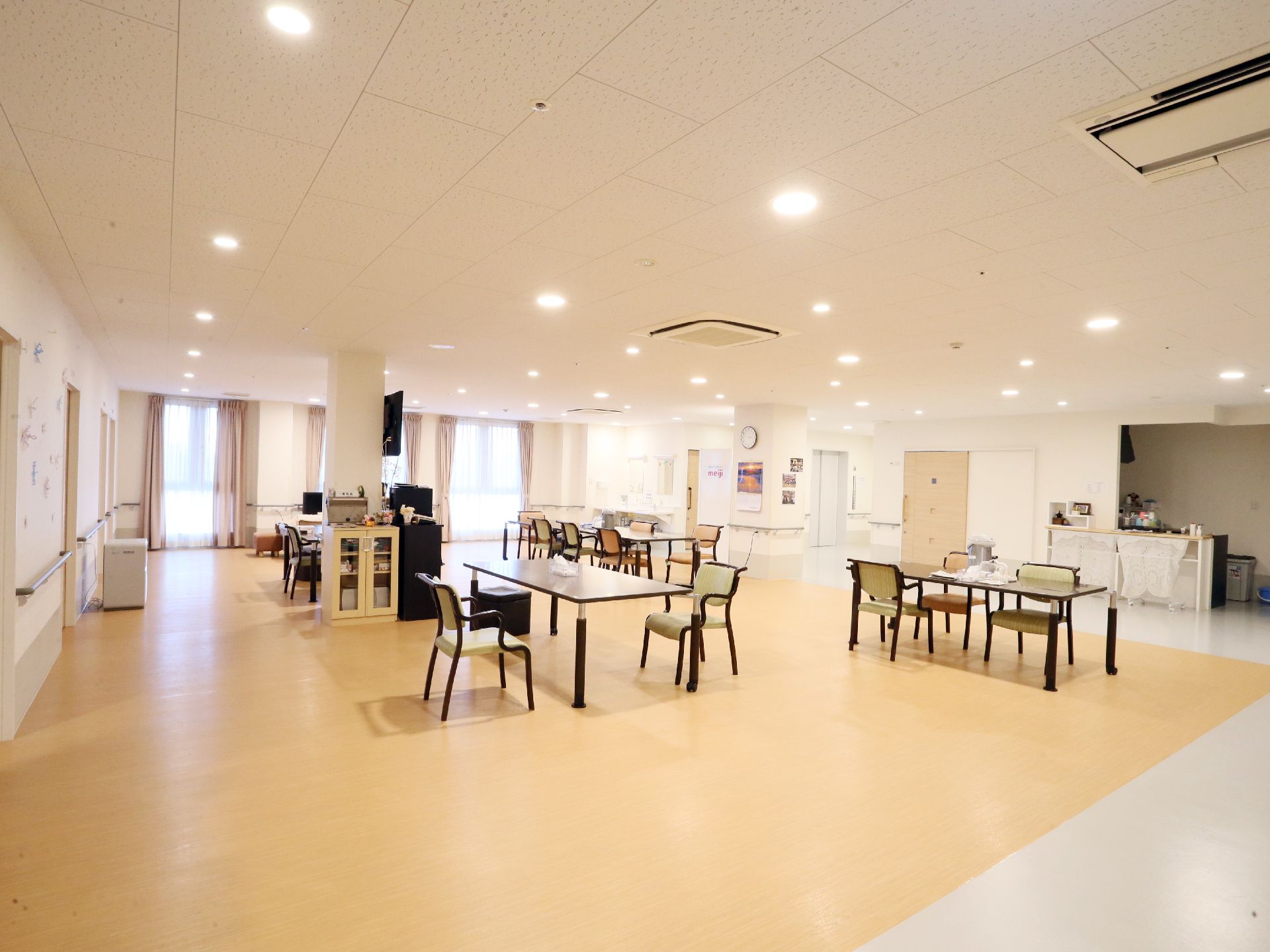 共用室は食堂としての機能も備えている。椅子やテーブルのほか、右手奥には食事を準備するためのキッチンが見える。