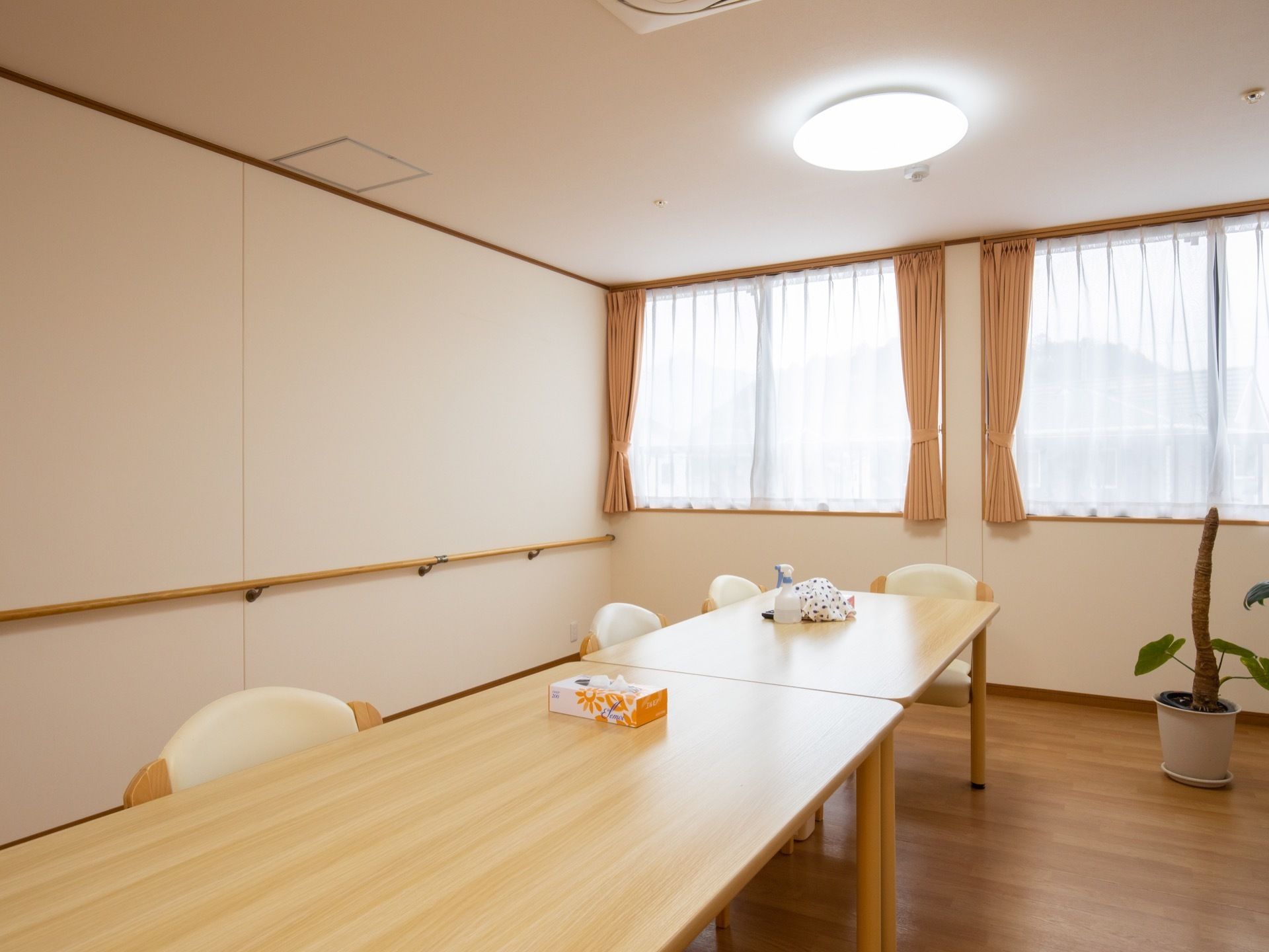 長方形のテーブルがくっついて並べられており、テーブルの上にはティッシュが置いてある。椅子が数脚用意されている。