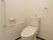 洋式のトイレは、手すりやトイレットペーパーフォルダもすべて白い色が使われている。非常時に使うボタンもある。