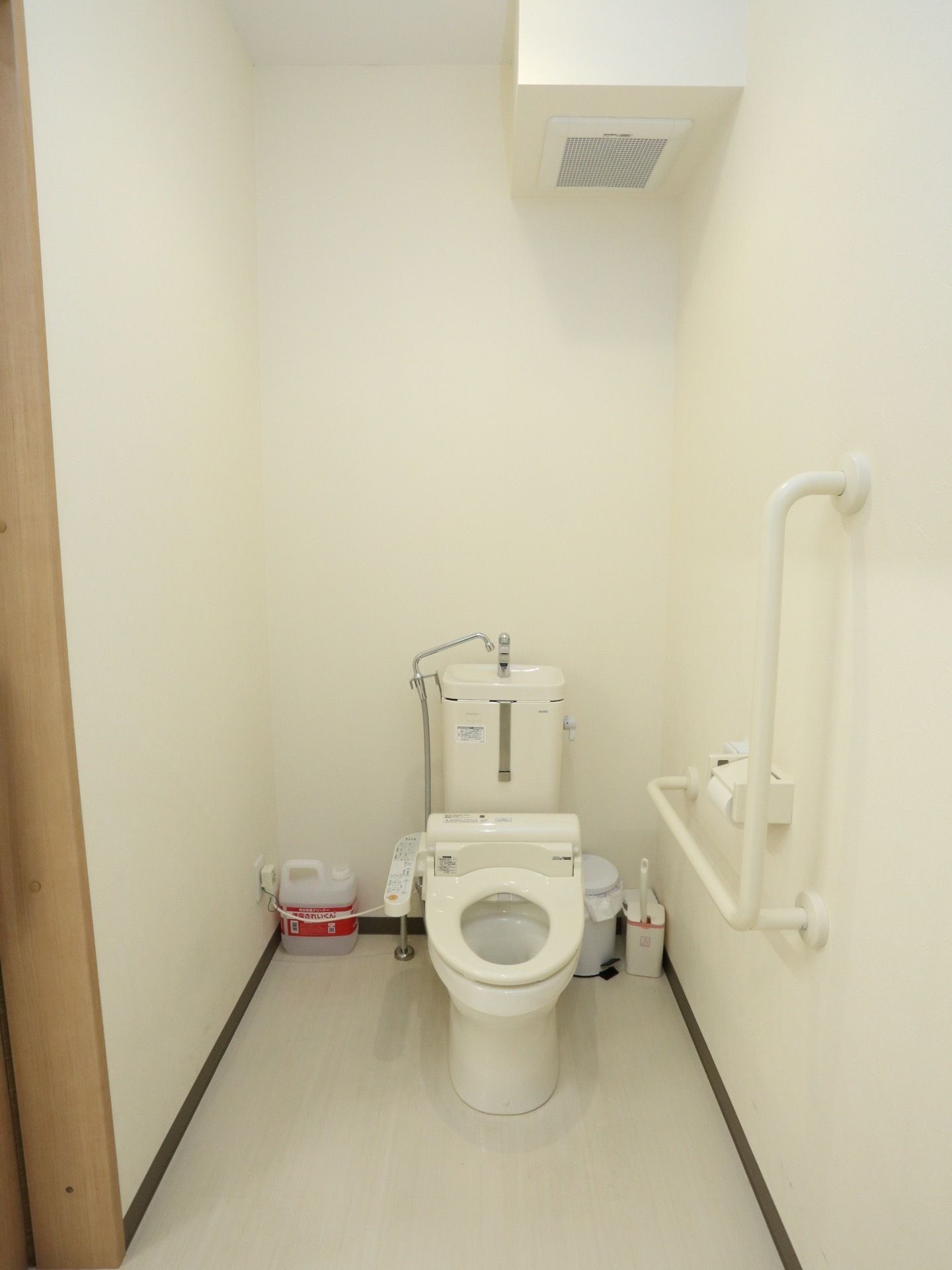 トイレは洋式で、白を基調とした室内である。トイレットペーパーフォルダの近くに手すりを取り付けている。