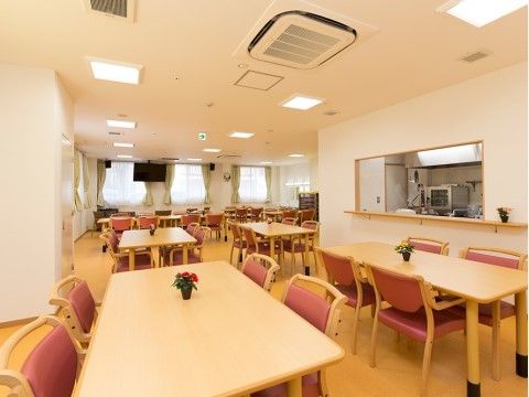 ダイニングは木の色合いを活かした家具を設置し、テーブルに花を飾るなど、入居者様が気持ちよくお食事ができる環境を整えている。