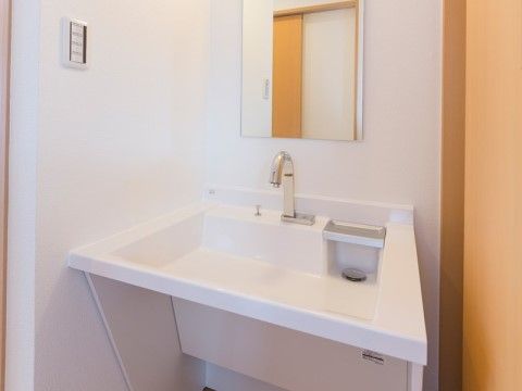 センサー式の蛇口で手を差し出すだけでご利用いただける。洗面台の下は、車椅子をご利用の方も座ったままご使用いただけるよう、設計してある。
