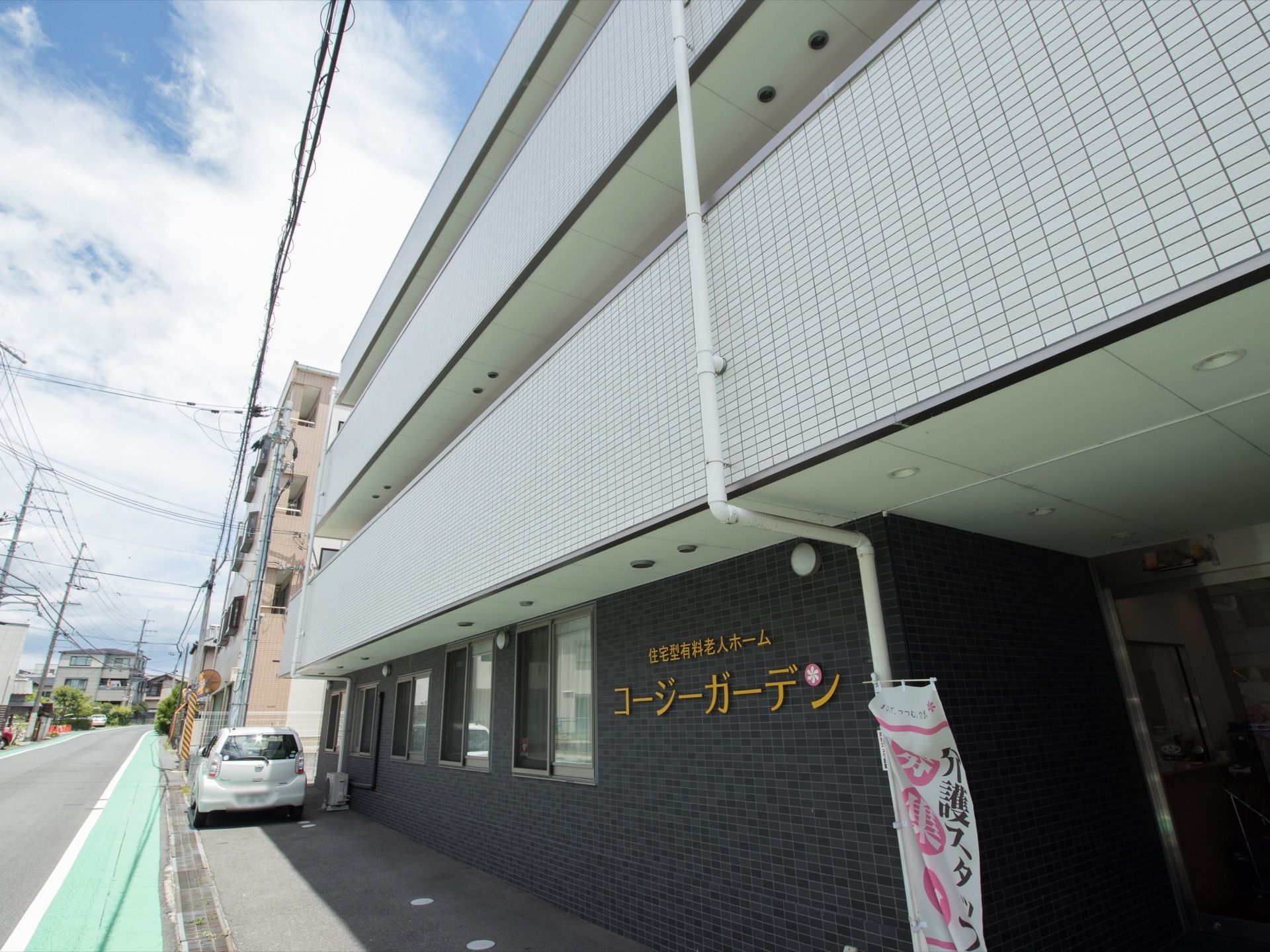 黒とグレーのタイル張りで高級感のある雰囲気となっている。住宅地の中に建つ地上3階建ての住宅型有料老人ホームである。