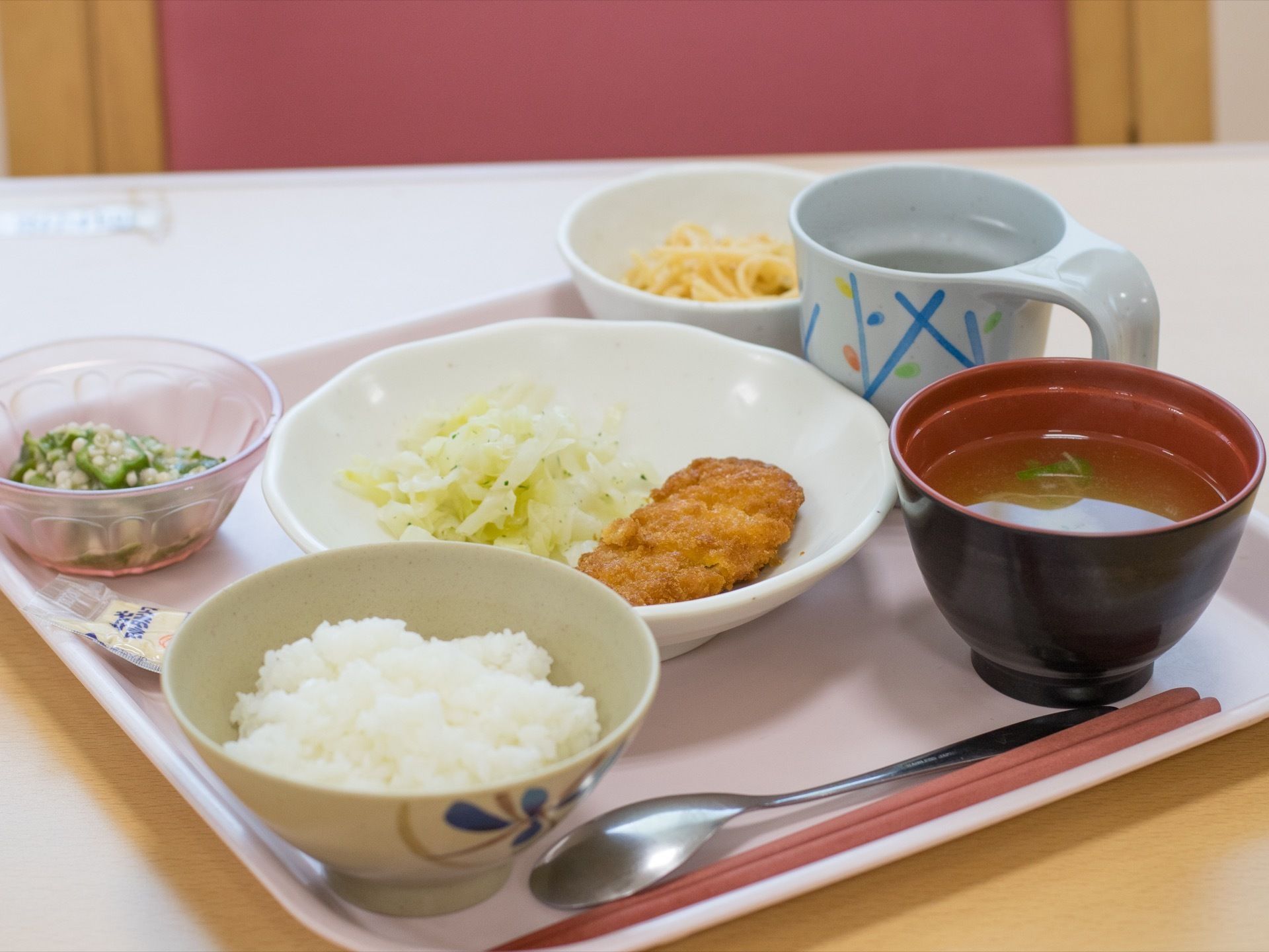 ある食事の献立。ご飯、みそ汁、おかずの揚げ物、付け合わせの和え物と麺。栄養バランスが良く、食べ応えもあるメニューとなっている。
