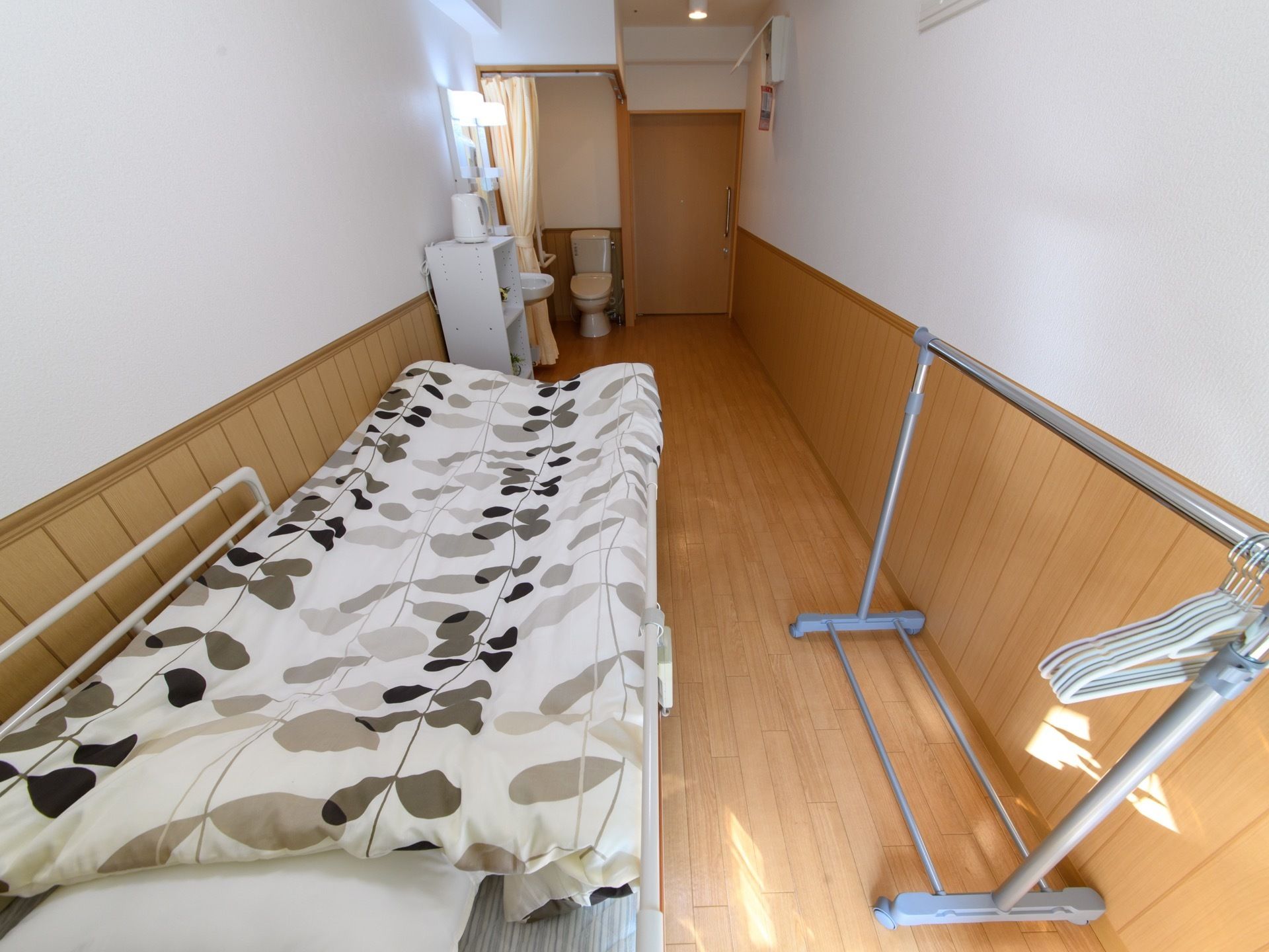 部屋にはベッドの他に、ハンガーラックや洗面台なども設置されている。清掃が行き届いており、非常に清潔感がある。