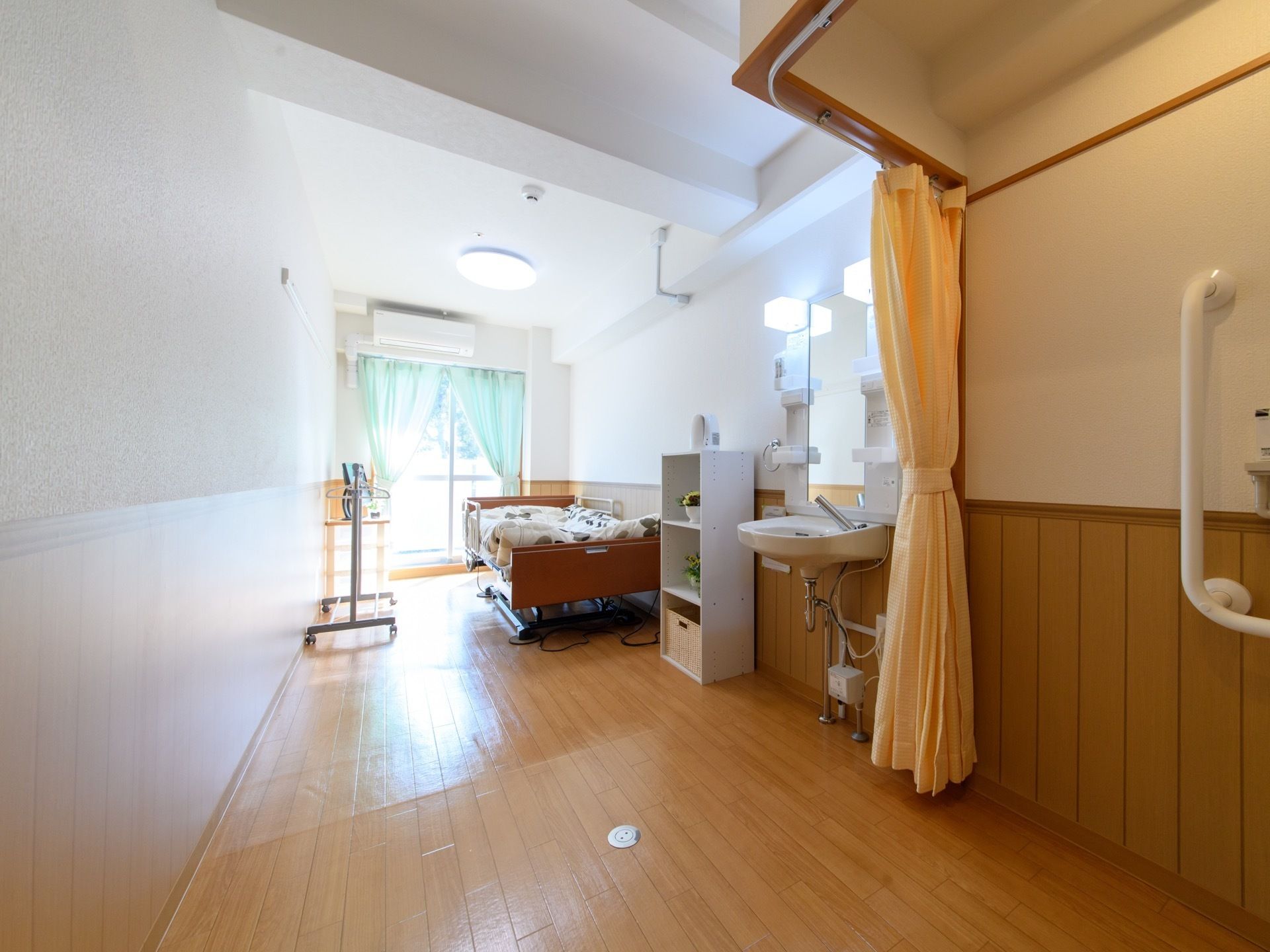 部屋にはベッドやハンガーのほか、洗面台も設置されている。フローリングで出来ているので、車椅子での移動にも不便はない。