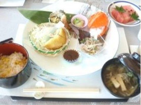 おかずがワンプレートに乗っており、汁物とご飯が付いた食事
