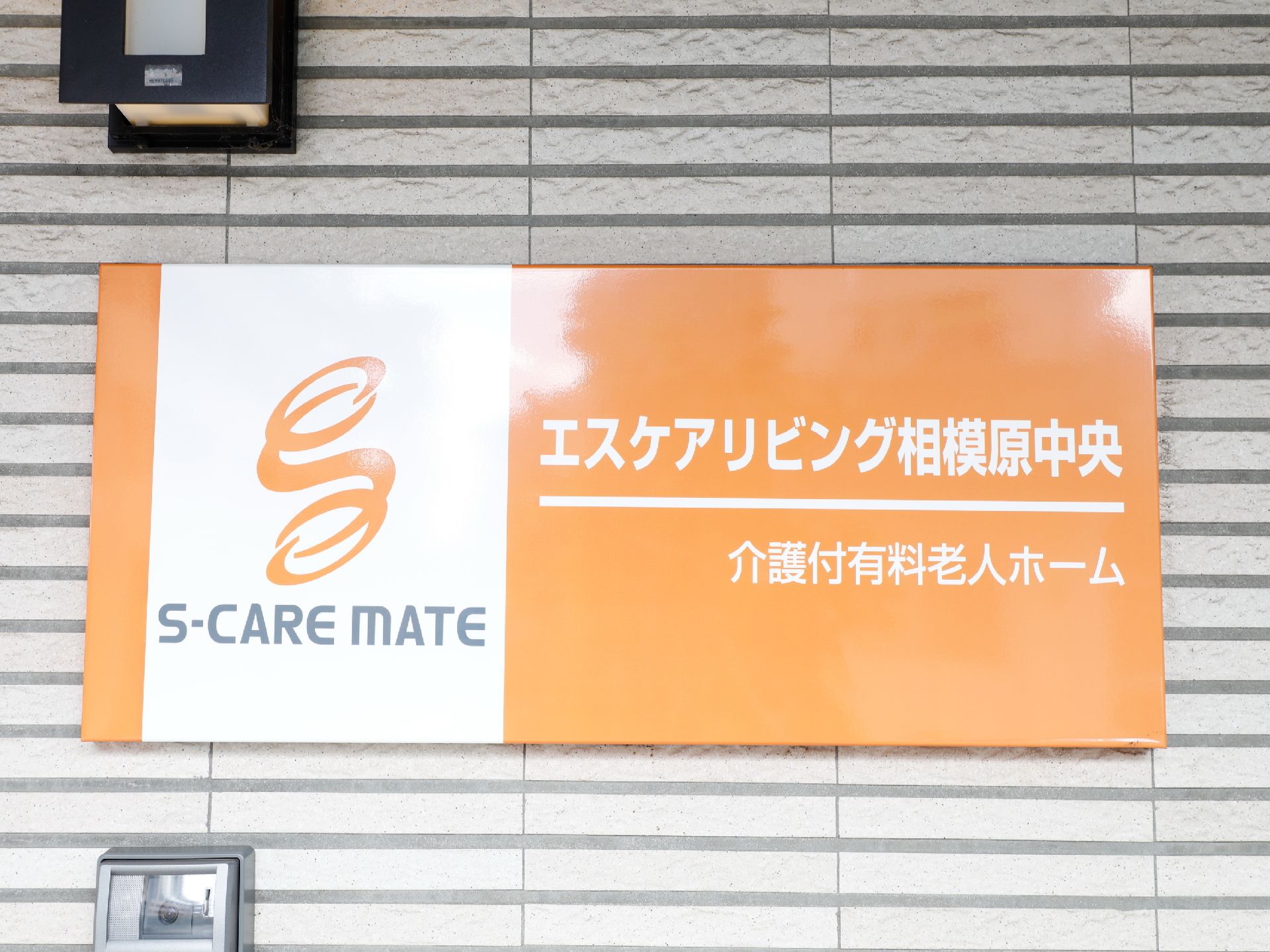 施設のプレートは横に長い長方形で、上段に施設の名前が白い文字で書かれており、下段に施設の種類が書かれている。
