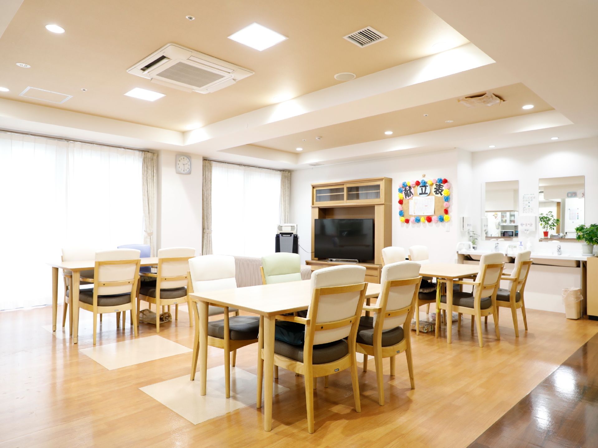 食堂には洗面台がある。4人掛けのテーブルがあり、明るく広い。正面には大きなテレビ、食事の献立表が可愛く飾ってある。