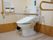 奥側の様式トイレは可動式の手すりが付いている。壁側には縦型の手すりがあり、緊急呼び出しのボタンがある。