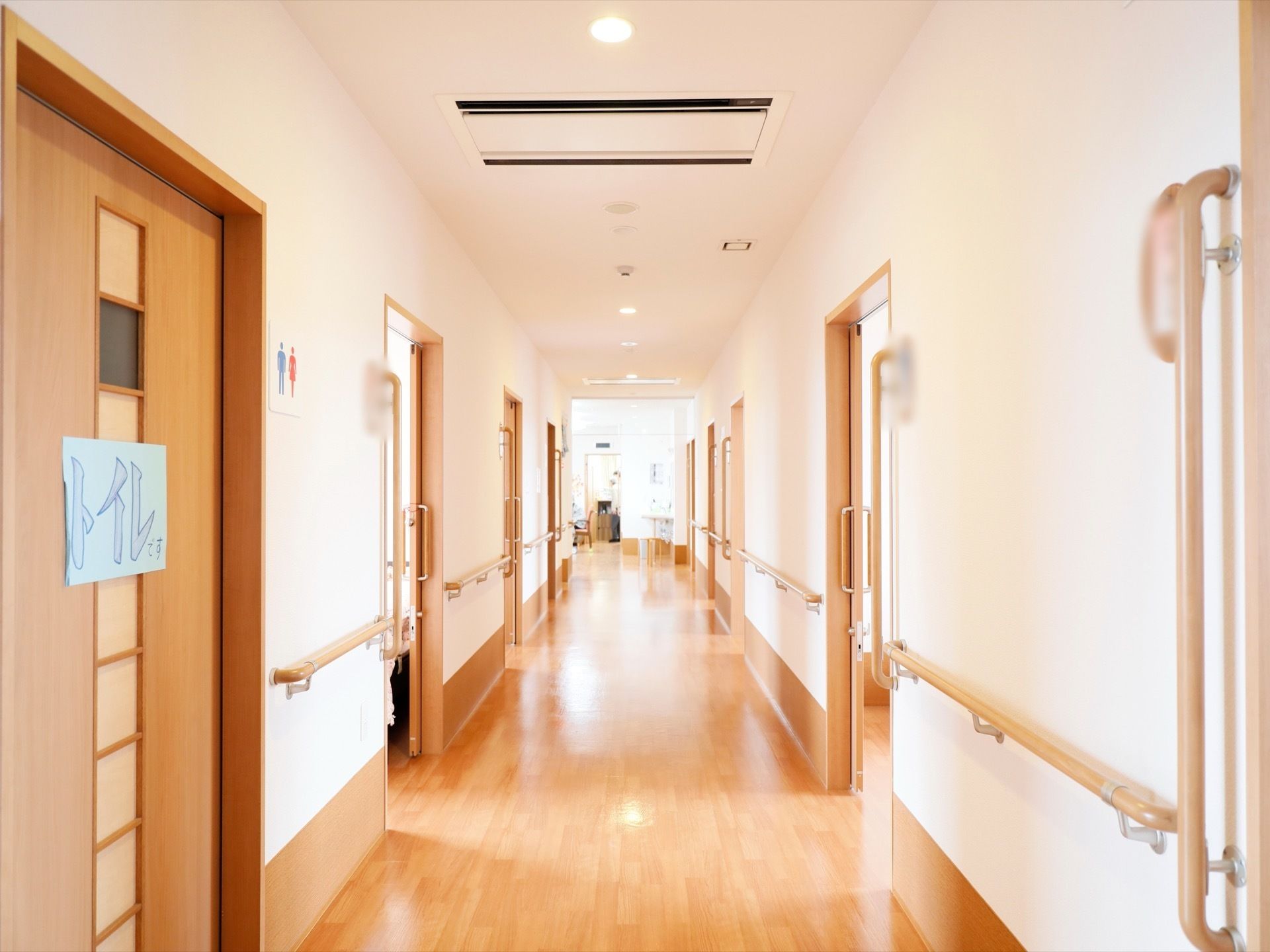 廊下には居室とトイレのドアが並んでいる。壁だけでなく、ドアの横にも手すりを縦に設置して、ドアが開いている際にもつかまる場所を確保している。