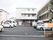 駐車場には、向かい合わせに駐車スペースをつくっている。施設の建物は３階建てで、窓が等間隔に並んでいる。
