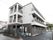 施設の建物は３階建てである。２、３階にはベランダがついている。外階段には屋根があり、１階にも扉がある。