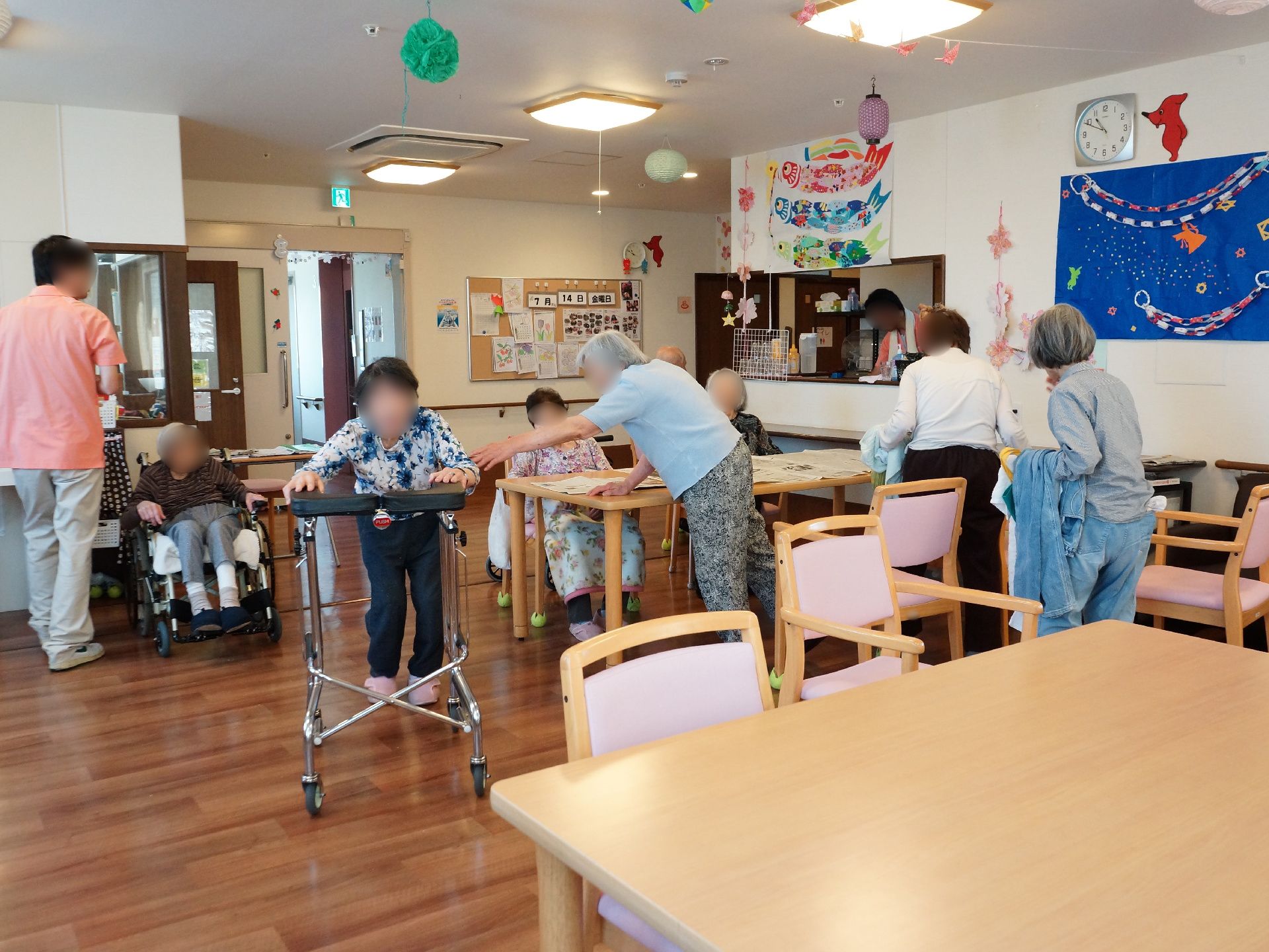 キッチンが併設されている明るい雰囲気の共有フロアでは入居者さんたちが談話を楽しんだり、歩行訓練をしたり、リラックスした時間を過ごしている。