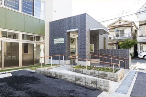「エイジ・ガーデン四條畷」の外観。閑静な住宅街に位置する3階建て、窓数が多い施設になっている。