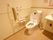 ゆったりとしたトイレスペースである。便座の横に洗面台を取付け、後部は棚になっている。壁に手すりを完備している。