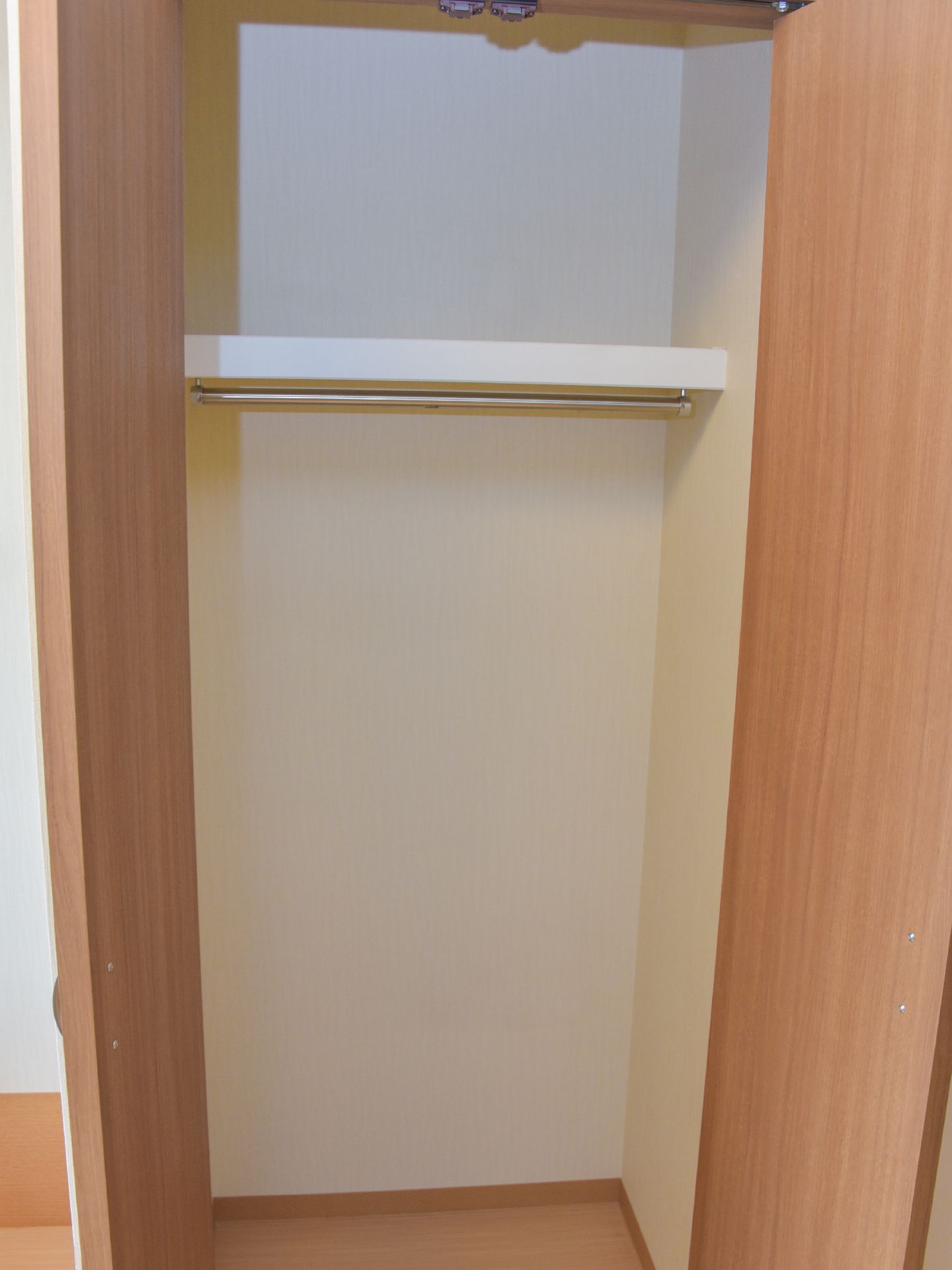 木製の背の高い棚で、両開きの扉がついている。内部は上下二つに区切られていて、ハンガーポールがついて服をかけられるようになっている。