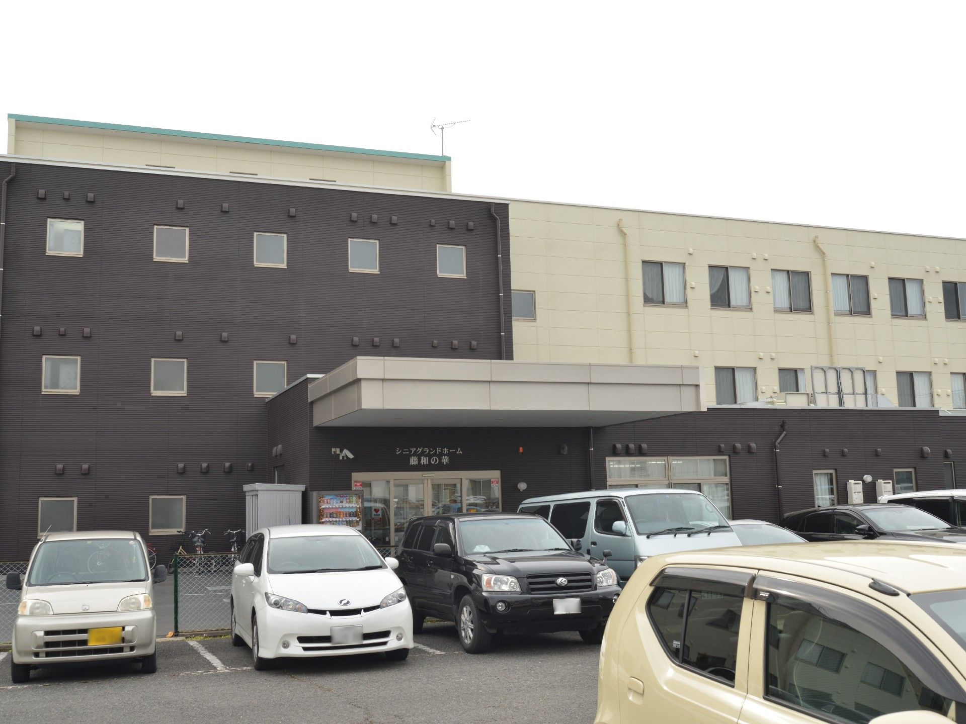 駐車場から見た施設入り口の様子。入り口の近くには、飲み物の自動販売機が設置されていて便利。車の他に自転車を停めるスペースがある。