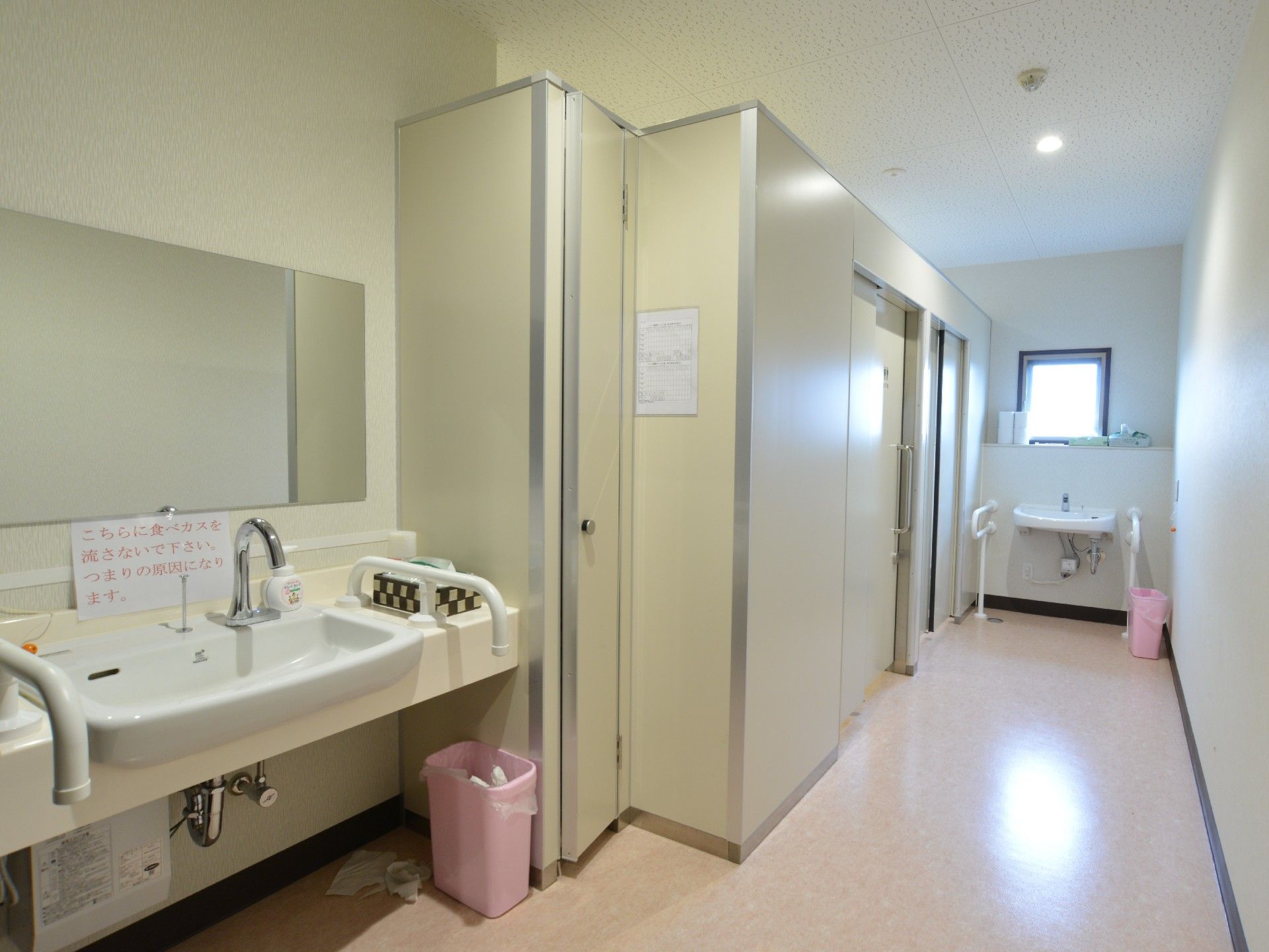 共用トイレは、入り口がスライド式のドアになっている。手前と奥に洗面台がある。洗面台の近くにも手すりがあり、安心できる。