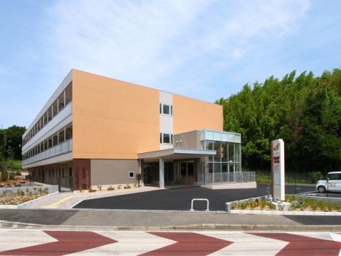 黄色い壁面と透明ガラスでできたロビーが印象的な外観