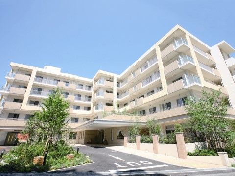 「グッドタイム リビング 香里ヶ丘－けやき通り－」の外観。すっきりとしたデザインの建物。