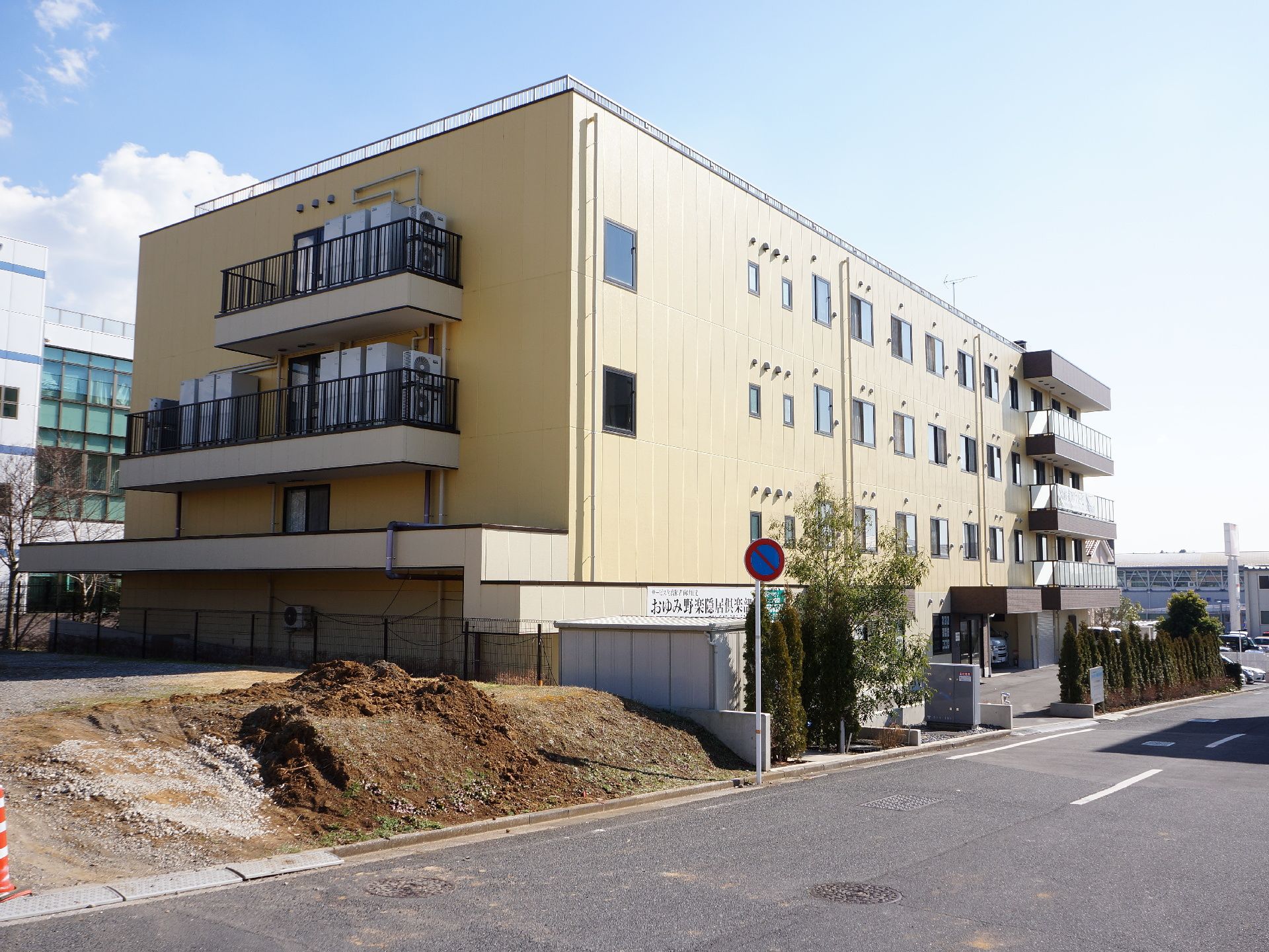 施設の外側には、2車線となっている広めの道路を確認することができる。また、空き地に土が盛り上がっている所もある。