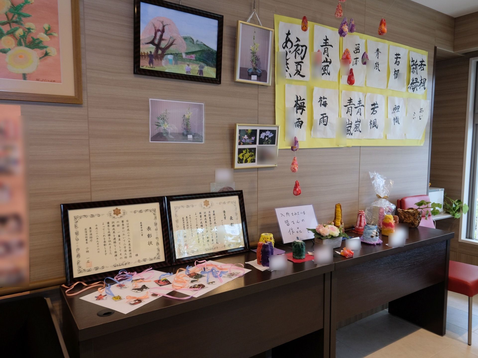 共有スペースの一部には、入居者様のクラブ活動での成果が掲示されている。書道や絵画、写真や手芸など、またそれらで表彰された賞状も飾られている。