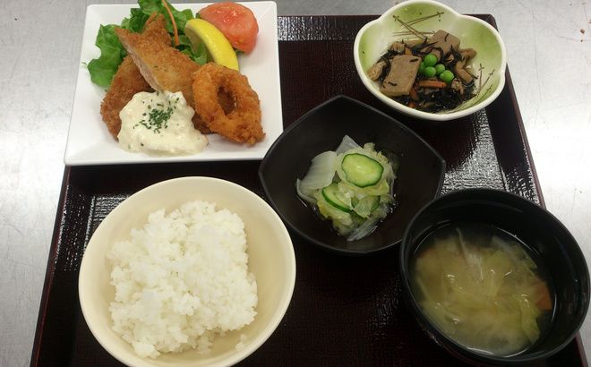 タルタルソースのかかったフライとひじきの煮物と味噌汁付いたメニュー
