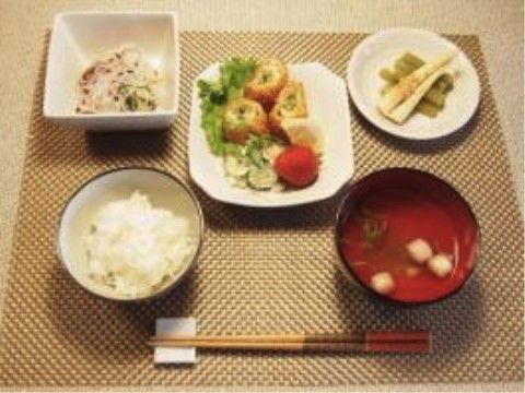 ランチョンマットの上に設置された、ご飯、汁物、おかず3品