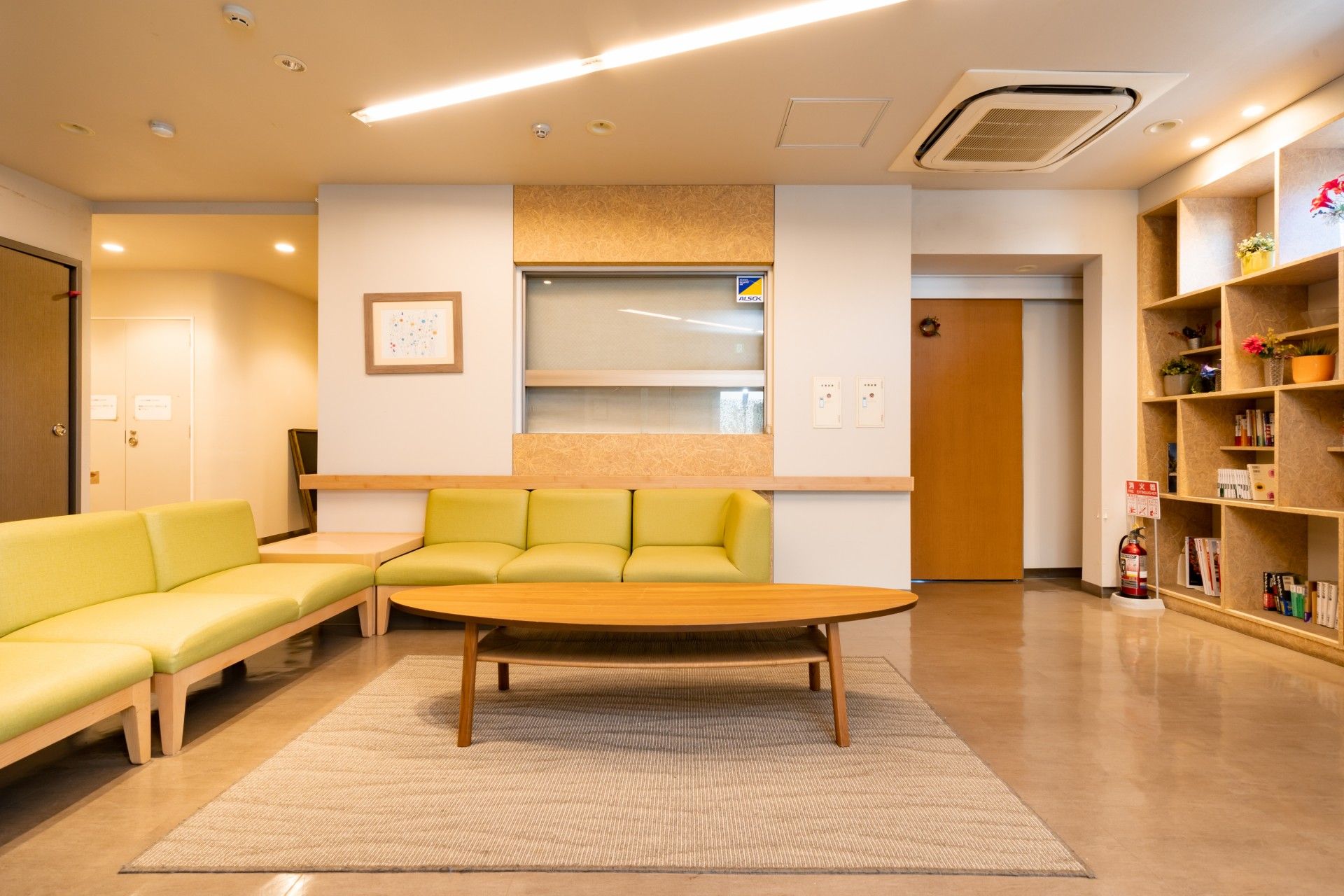 長いテーブルをはさんで２列に座り、手作りの兜を頭にかぶる入居者