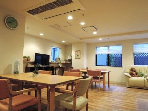 アームレスト付きの椅子が備わったテーブルセットとソファー、テレビ、エアコンが備えられた食堂