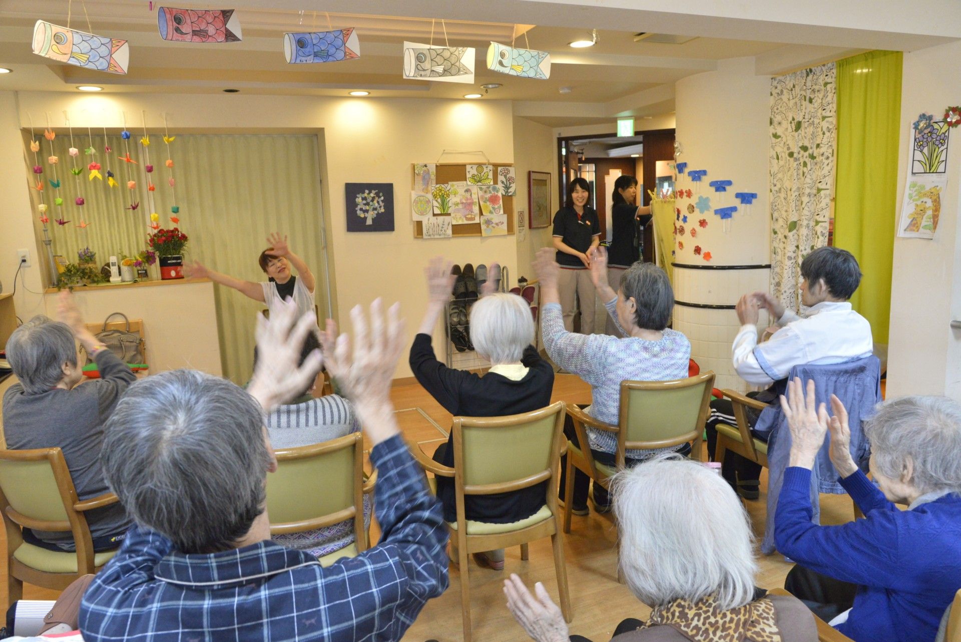 お出掛け先で、花壇の前に１列に並んで座る入居者の方々