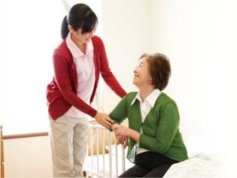 笑顔で手をつなぐスタッフと入居者