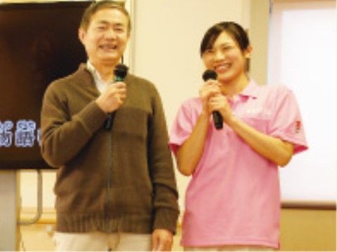 笑顔でマイクを持つスタッフと利用者