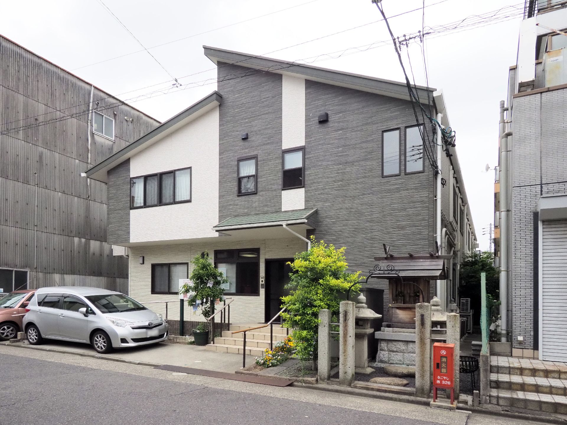 グループホームの入り口付近には社が祀らている。またエントランスにはガーデンスペースがあり、針葉樹が植えられている。