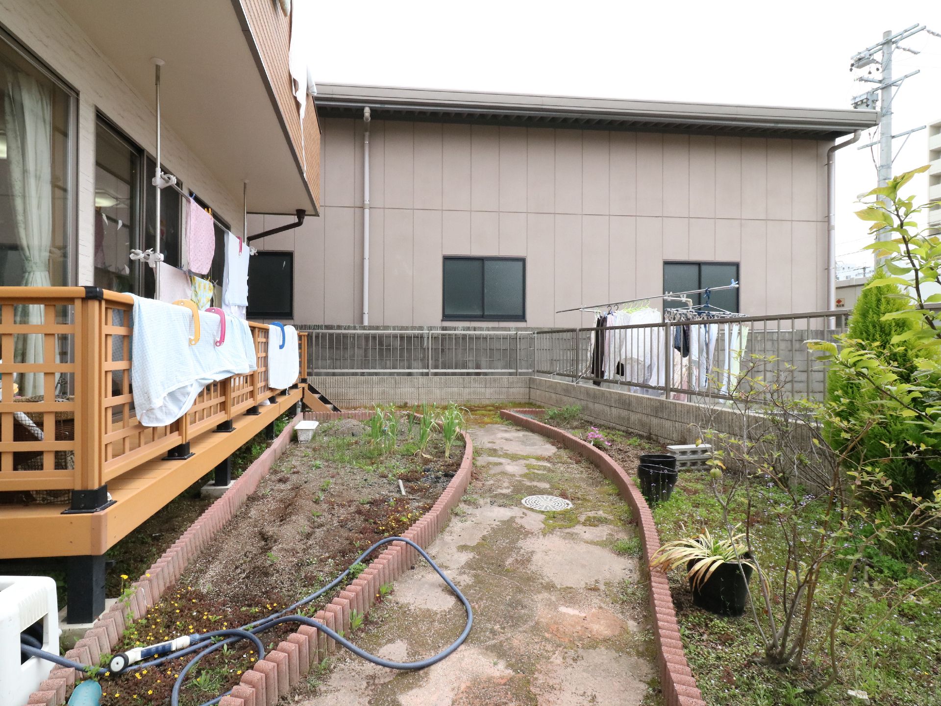建物の外には庭があり、小道をはさんで花壇が作られている。庭に面したバルコニーには布団を干すことが出来る。