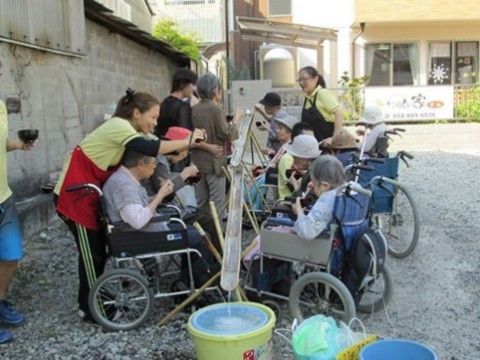 敷地内で流しそうめんを楽しむ施設スタッフと入居者の方々
